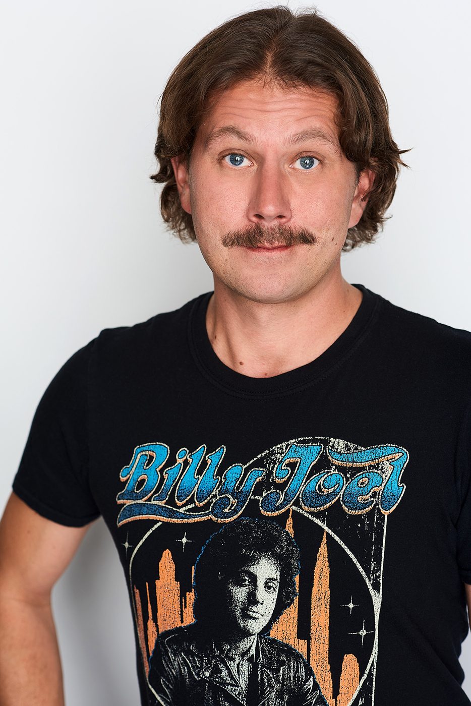 Joe Uhlarik headshot, deadpan expression, Billy Joel t-shirt