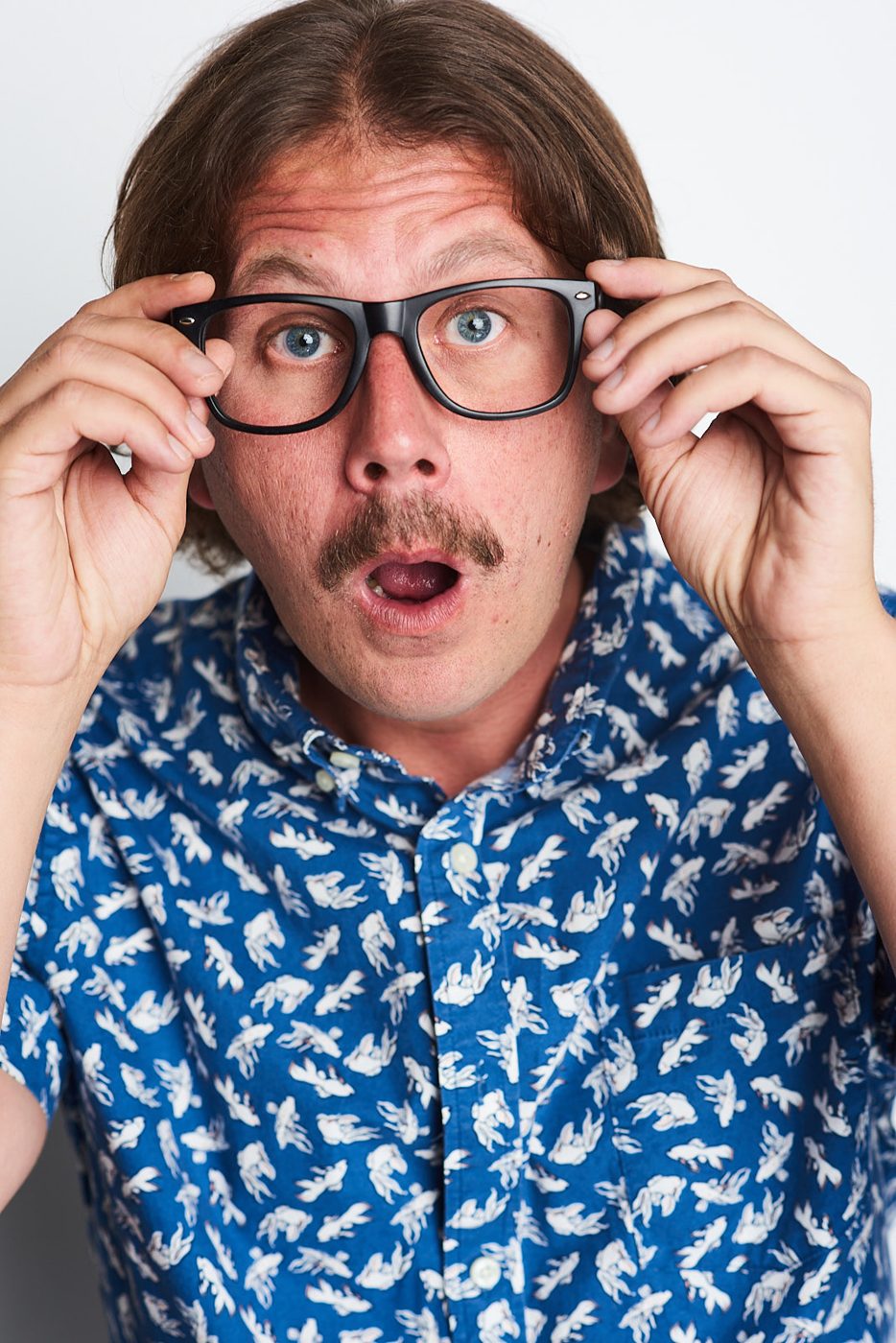 Joe Uhlarik holding glasses, mouth open, wacky headshot