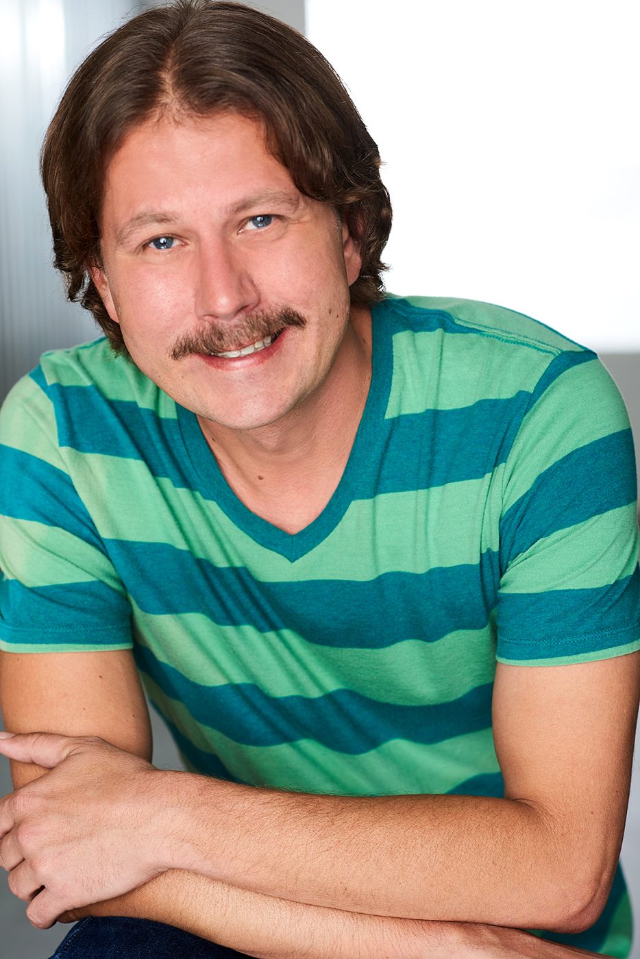 Joe Uhlarik headshot, smiling, striped shirt